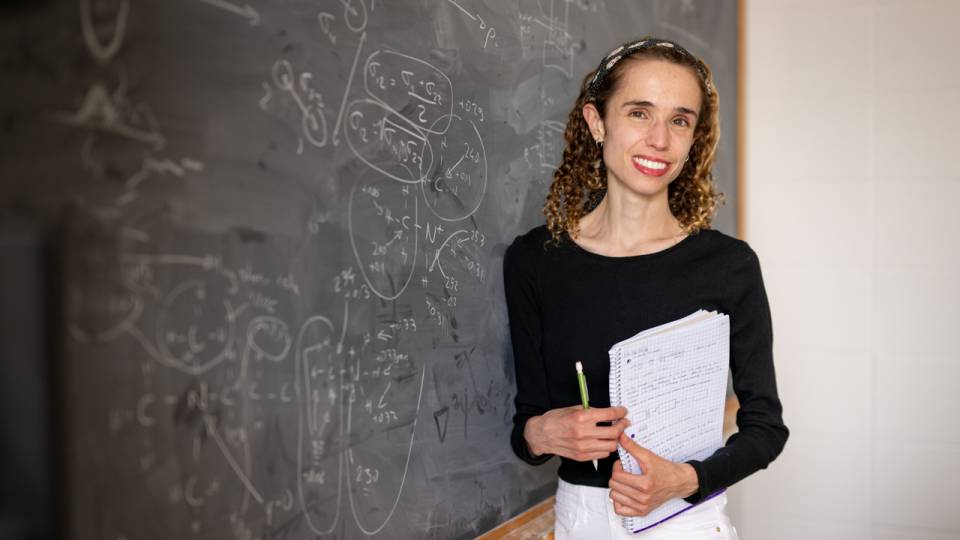 Amelie standing next to a blackboard