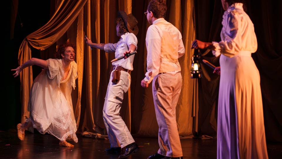 An actor snarls at another group of actors on stage